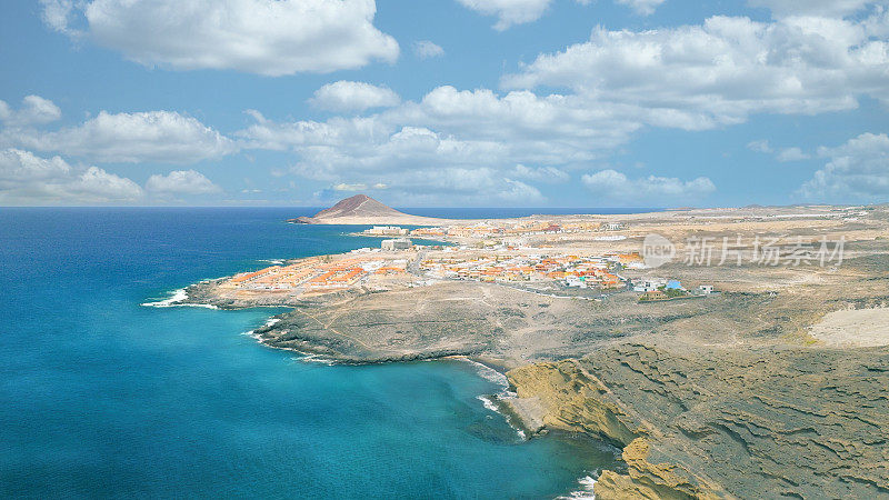 Aerial view of the coast in the natural reserve of "Montaña Pelada" and town of El Medano in the background. Tenerife, Canary Islands. Drone shot